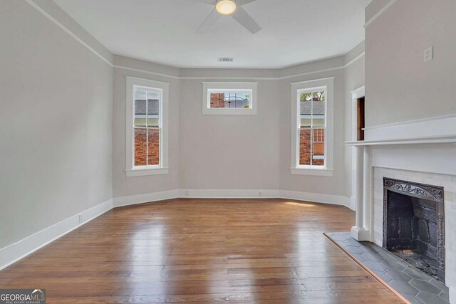 815 E Henry St, Savannah, GA 31401 - unfurnished living room featuring a fireplace, wood-type flooring, and a ceiling fan