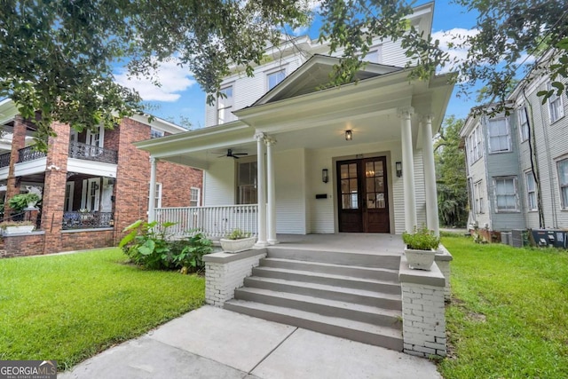 view of front of house with covered porch, french doors, and a front lawn