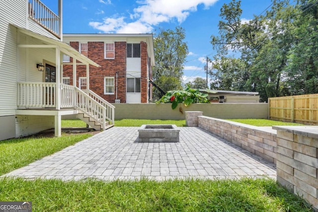 view of patio with an outdoor fire pit and fence