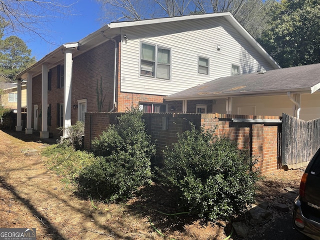 view of home's exterior featuring fence and brick siding