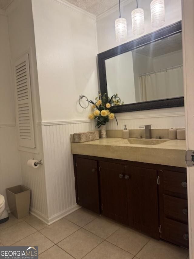 bathroom featuring tile patterned floors, a wainscoted wall, vanity, and ornamental molding