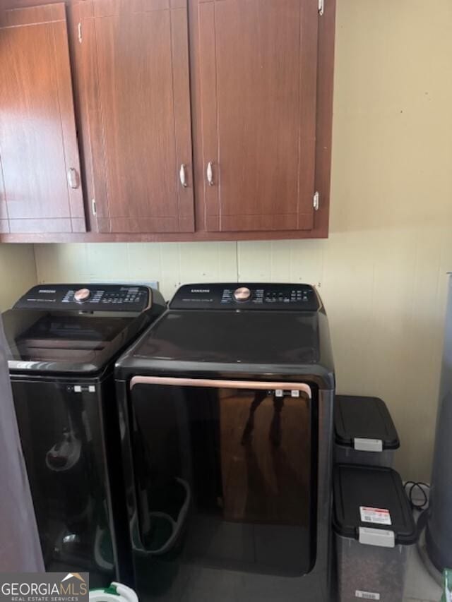 washroom featuring washer and dryer and cabinet space