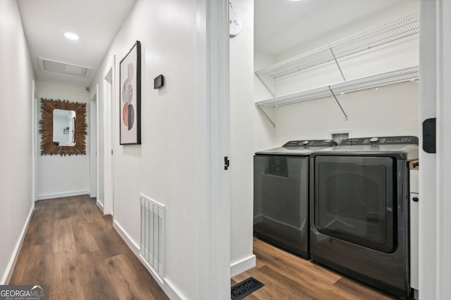 washroom featuring washer and dryer, wood finished floors, visible vents, and baseboards