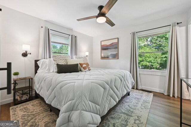 bedroom featuring baseboards, wood finished floors, and a ceiling fan