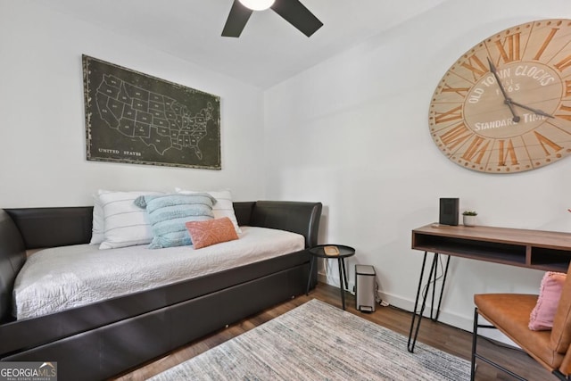 bedroom featuring baseboards, wood finished floors, and a ceiling fan