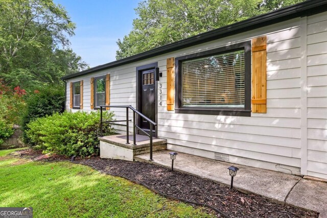 view of front facade with crawl space and a front lawn