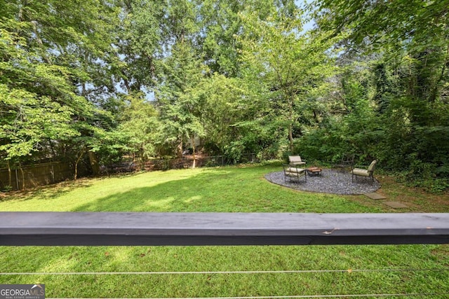 view of yard featuring an outdoor fire pit and fence