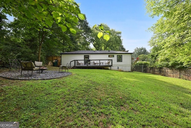 rear view of property with a yard, a fenced backyard, and a wooden deck