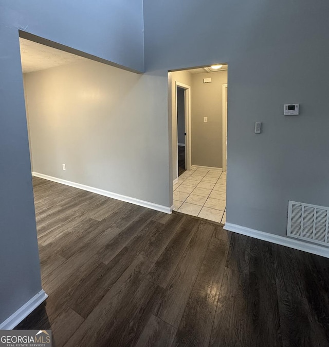 empty room with visible vents, baseboards, and wood finished floors