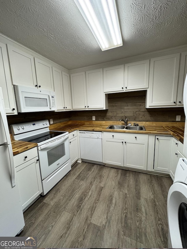 kitchen with white appliances, washer / dryer, dark wood-style floors, wooden counters, and a sink