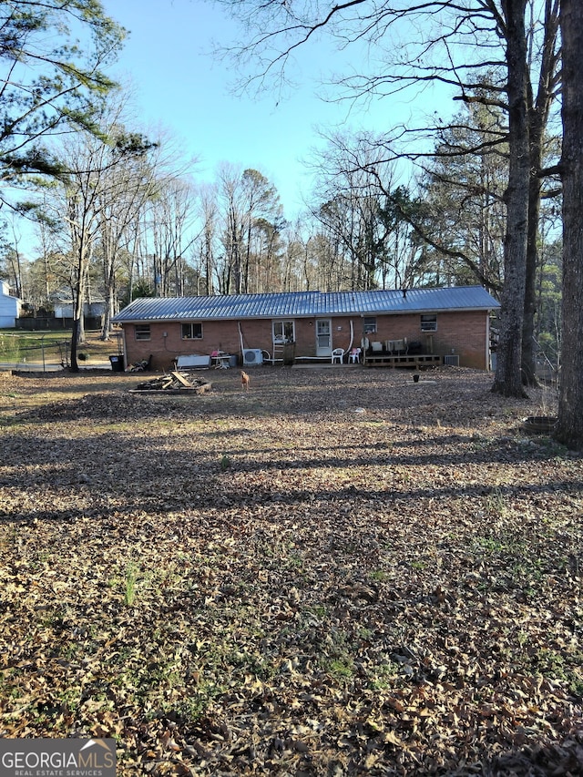 back of house featuring metal roof