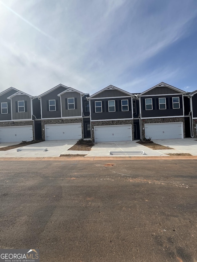 multi unit property with an attached garage and concrete driveway