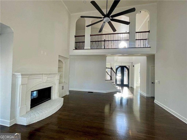 3499 Lake Mill Rd, Buford, GA 30519 - unfurnished living room featuring ceiling fan, a towering ceiling, wood finished floors, a fireplace, and stairway