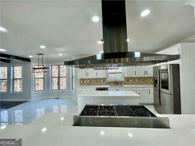 kitchen featuring marble finish floor, island exhaust hood, tasteful backsplash, appliances with stainless steel finishes, and a sink