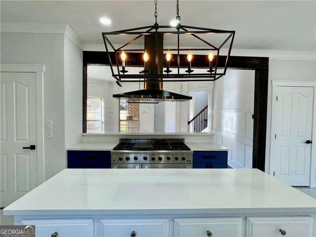 kitchen with wall chimney exhaust hood, ornamental molding, high end stove, and white cabinetry