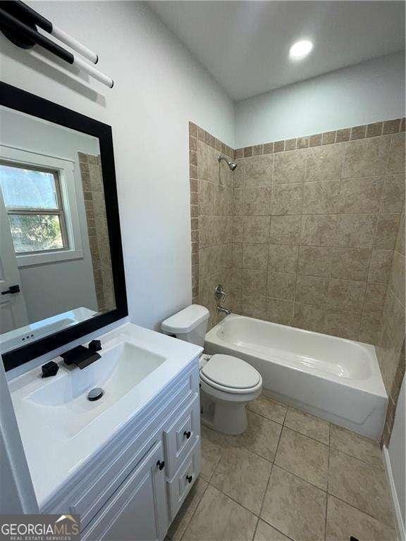 full bathroom featuring toilet, vanity, tile patterned flooring, and washtub / shower combination