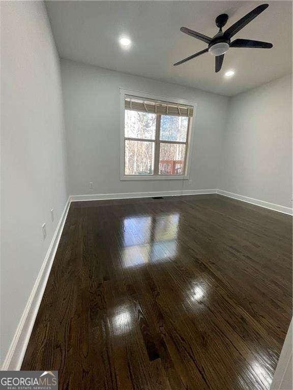 empty room with dark wood-style floors, recessed lighting, a ceiling fan, and baseboards