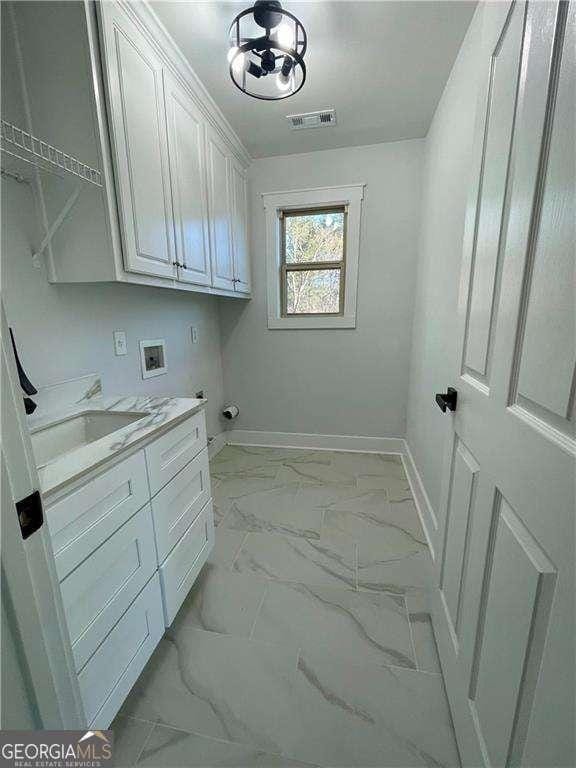 laundry room featuring marble finish floor, hookup for a washing machine, visible vents, cabinet space, and baseboards