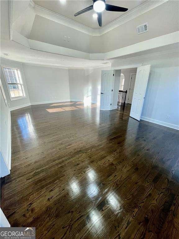 3499 Lake Mill Rd, Buford, GA 30519 - spare room featuring baseboards, ceiling fan, wood finished floors, a raised ceiling, and crown molding