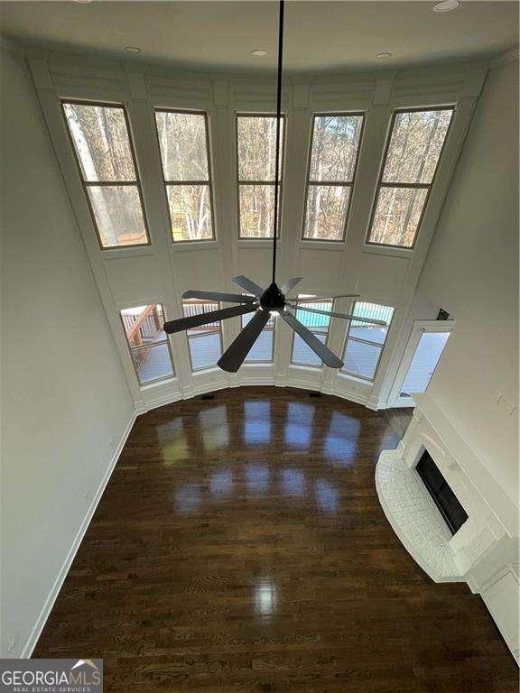 3499 Lake Mill Rd, Buford, GA 30519 - unfurnished living room featuring baseboards, wood finished floors, and a ceiling fan