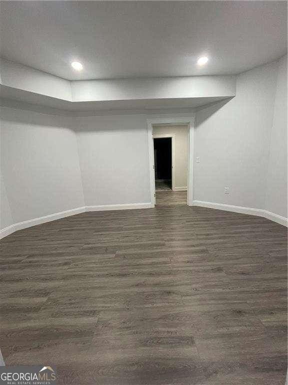 below grade area featuring baseboards, dark wood-type flooring, and recessed lighting