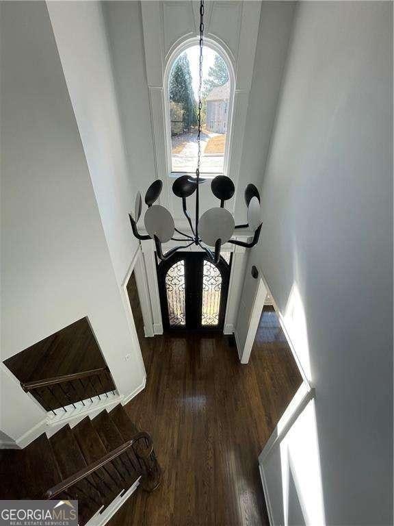 foyer entrance featuring baseboards, dark wood-style flooring, and a notable chandelier