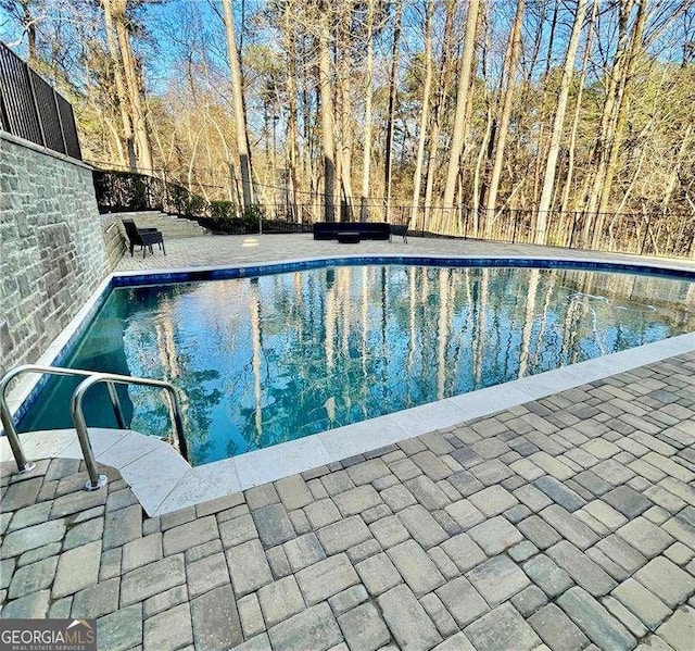 view of swimming pool with a fenced in pool, fence, and a patio