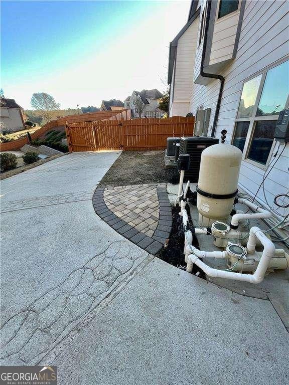 view of patio featuring central AC unit and fence