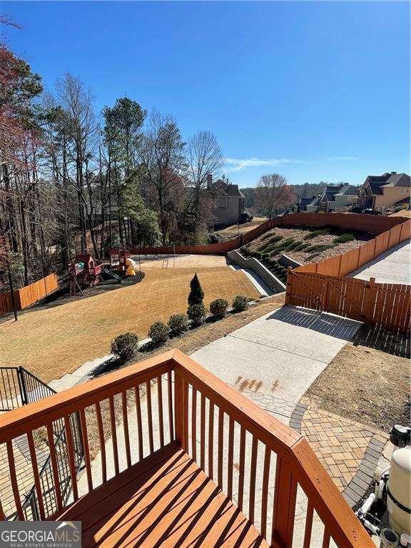 wooden deck with a lawn and fence