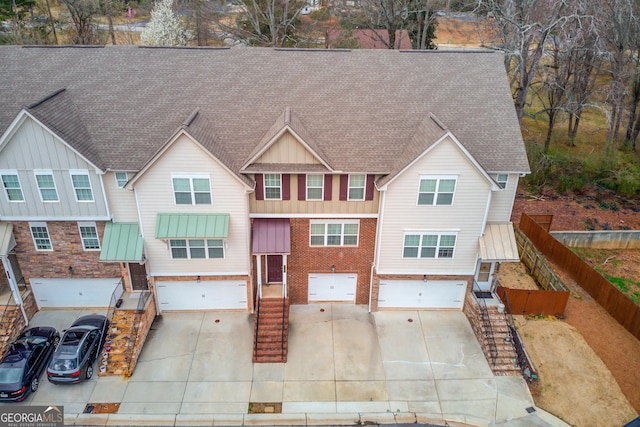 view of front facade with a garage, fence, and driveway