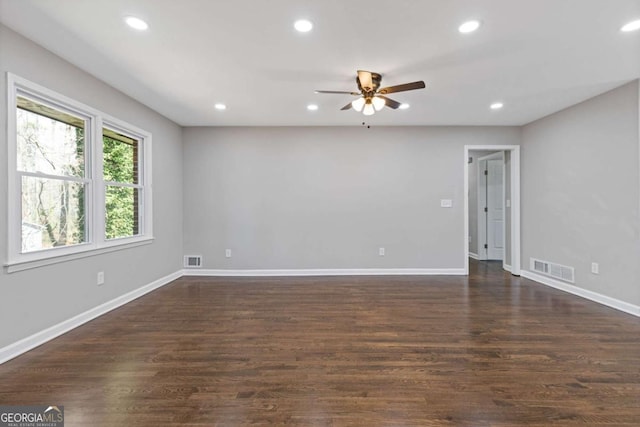 unfurnished room with dark wood-type flooring, visible vents, and recessed lighting