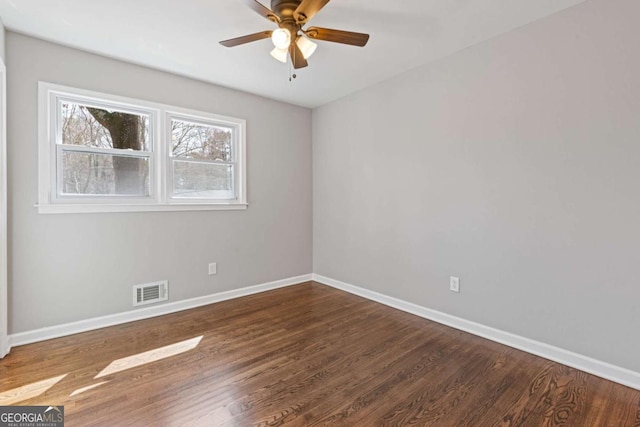 spare room featuring a ceiling fan, baseboards, and wood finished floors