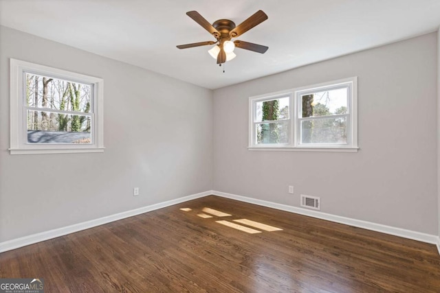 unfurnished room featuring a healthy amount of sunlight, baseboards, and visible vents