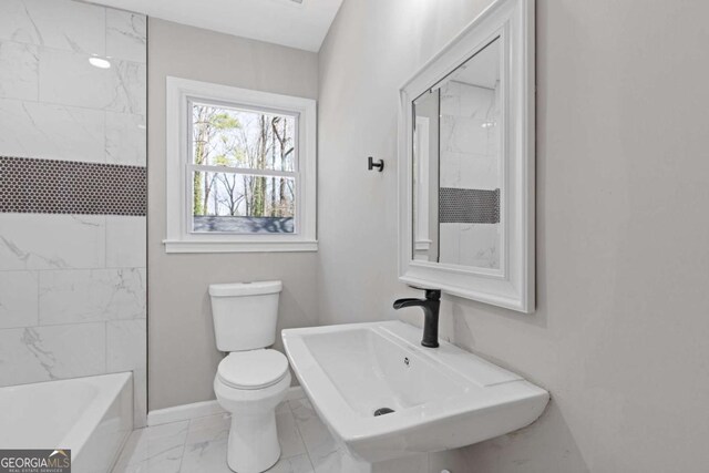 5277 Cardinal Ln NW, Lilburn, GA 30047 - bathroom with marble look tile flooring and washtub / shower combination