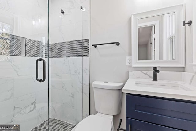 bathroom with a stall shower, vanity, and toilet