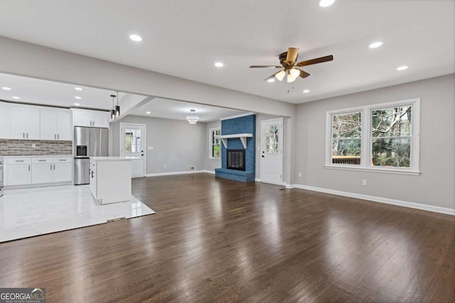 5277 Cardinal Ln NW, Lilburn, GA 30047 - unfurnished living room with ceiling fan, healthy amount of natural light, recessed lighting, a fireplace, and wood finished floors