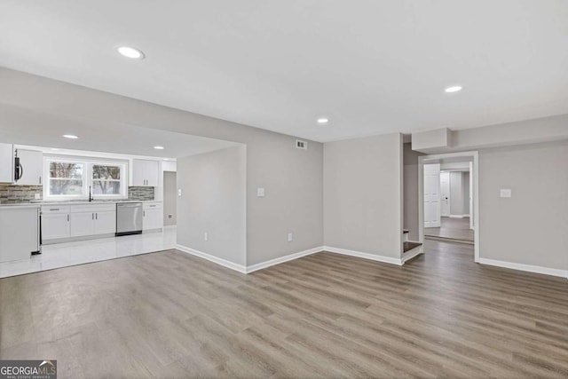 unfurnished living room featuring light wood-style flooring, visible vents, baseboards, and recessed lighting