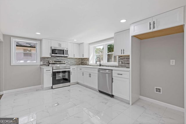 5277 Cardinal Ln NW, Lilburn, GA 30047 - kitchen featuring stainless steel appliances, light marble finish floors, decorative backsplash, white cabinets, and recessed lighting