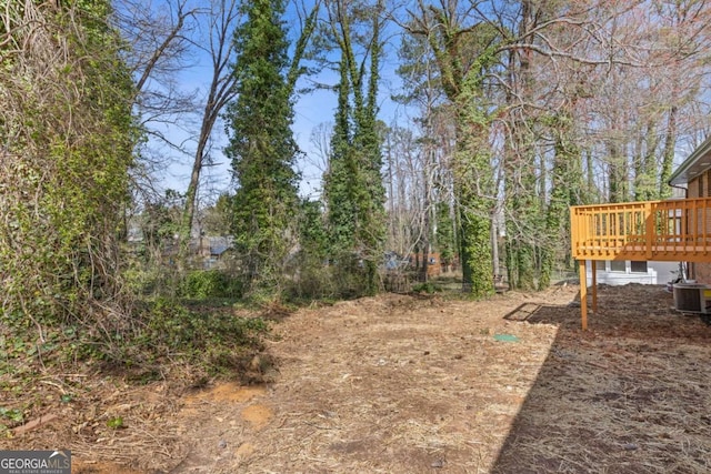 view of yard with a deck and central air condition unit