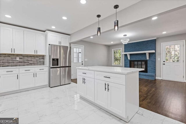 5277 Cardinal Ln NW, Lilburn, GA 30047 - kitchen with stainless steel refrigerator with ice dispenser, light marble finish flooring, hanging light fixtures, recessed lighting, and white cabinets