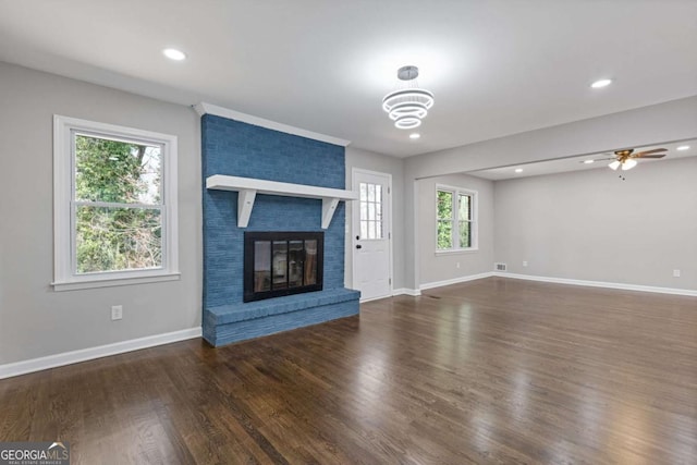 unfurnished living room with recessed lighting, visible vents, a brick fireplace, wood finished floors, and baseboards