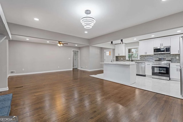 5277 Cardinal Ln NW, Lilburn, GA 30047 - kitchen with appliances with stainless steel finishes, open floor plan, a ceiling fan, light countertops, and white cabinets