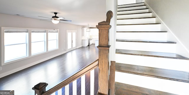 stairway featuring a ceiling fan, wood finished floors, and baseboards