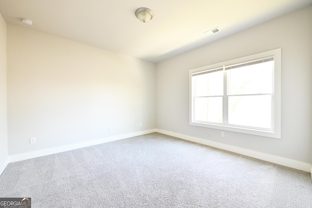 unfurnished room featuring visible vents, baseboards, and carpet flooring