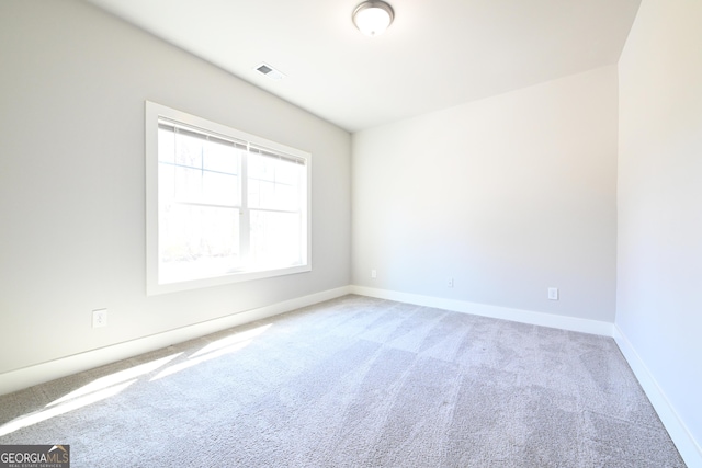 empty room featuring visible vents, baseboards, and carpet