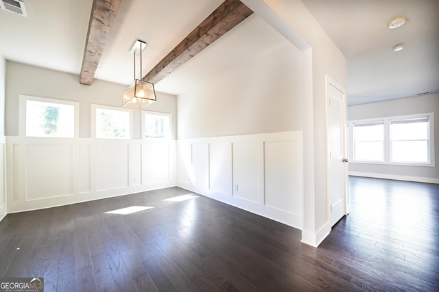 unfurnished dining area featuring beam ceiling, visible vents, dark wood finished floors, and a decorative wall