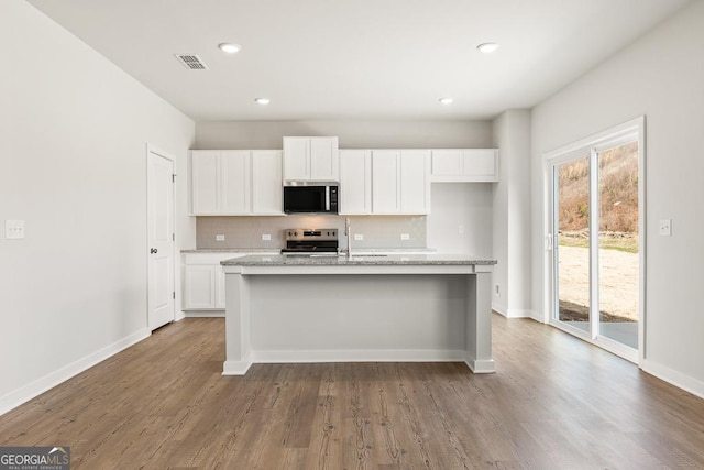 kitchen featuring appliances with stainless steel finishes, white cabinets, and tasteful backsplash