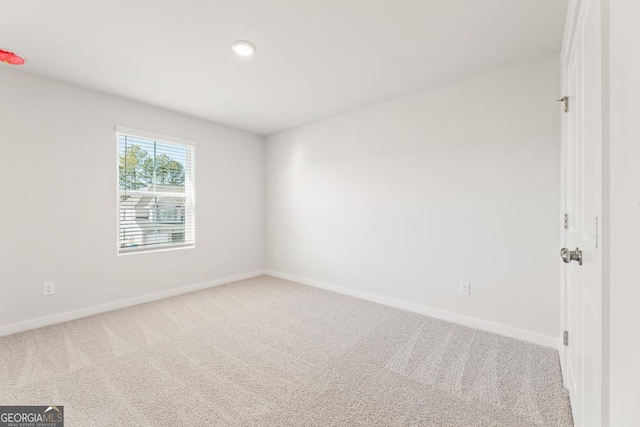 carpeted spare room featuring baseboards