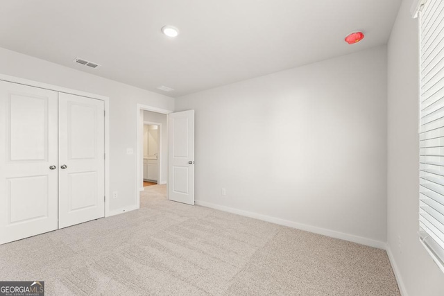 unfurnished bedroom with a closet, baseboards, visible vents, and carpet flooring