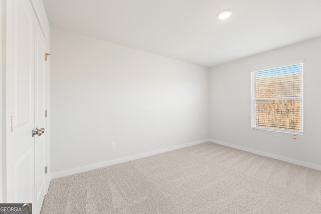 carpeted spare room with baseboards